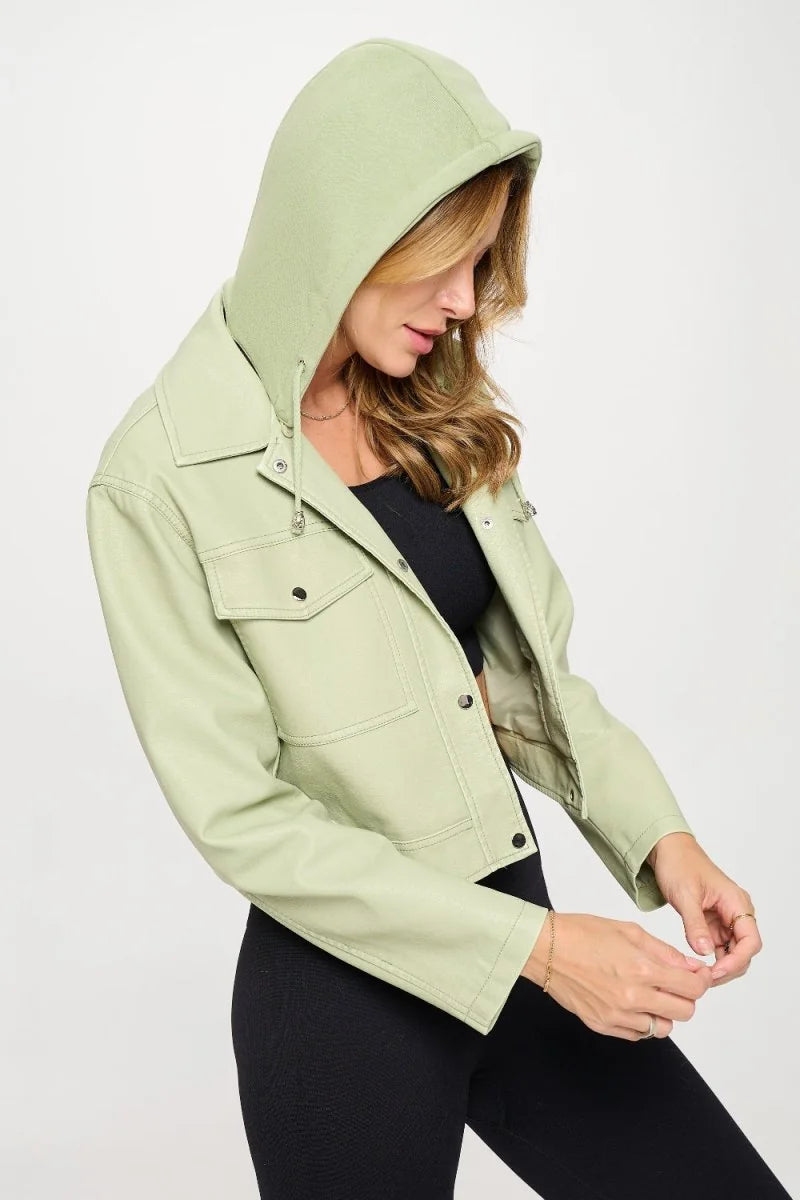 Light green vegan leather cropped jacket with hood, chest pockets, and silver snaps on a model.