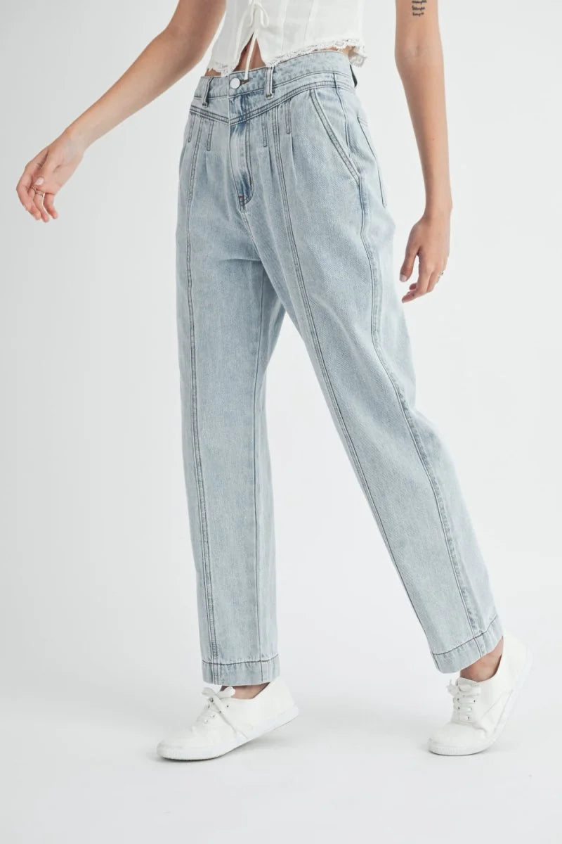 Light wash denim jeans with prominent front seams and a relaxed fit.