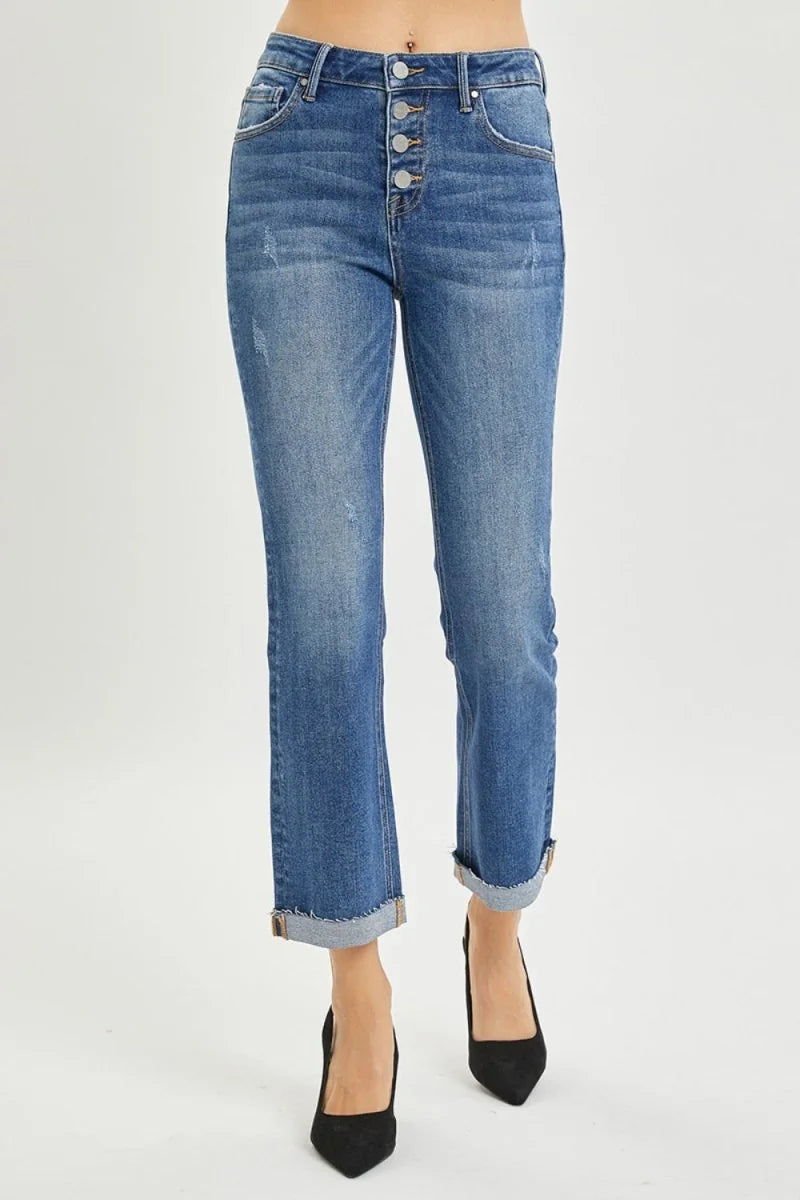 Distressed medium wash denim jeans with a button fly and cuffed hem.