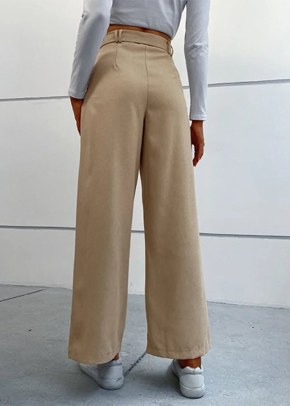 Tan wide-leg pants with belt loops and a high waist, shown on a model from the back.