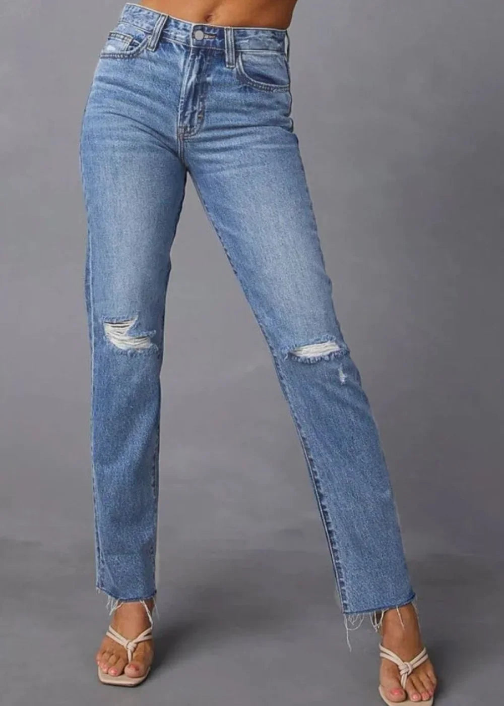 Distressed light wash denim jeans with a frayed hem and a straight leg fit.