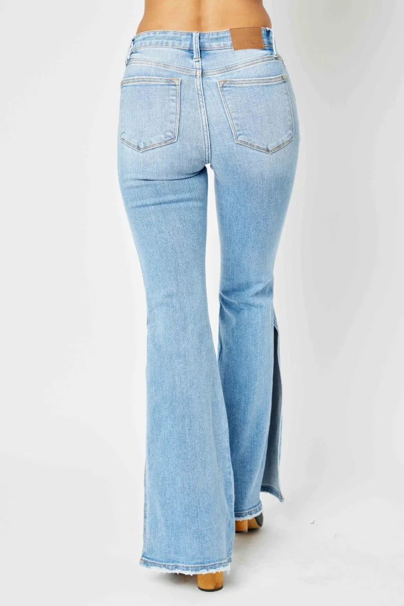 Light wash denim flare jeans with high waist and side slit detail.