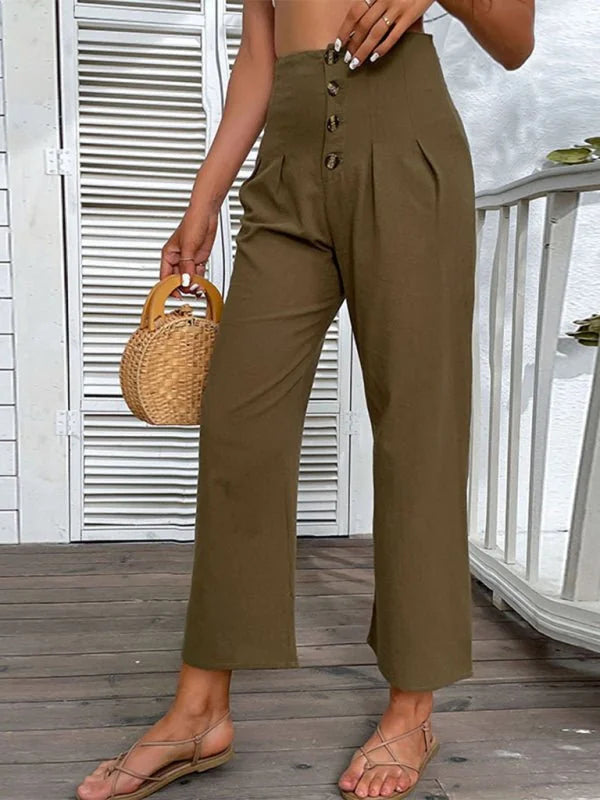 Khaki high-waisted wide-leg pants with button closure and pleats, worn with flat sandals.