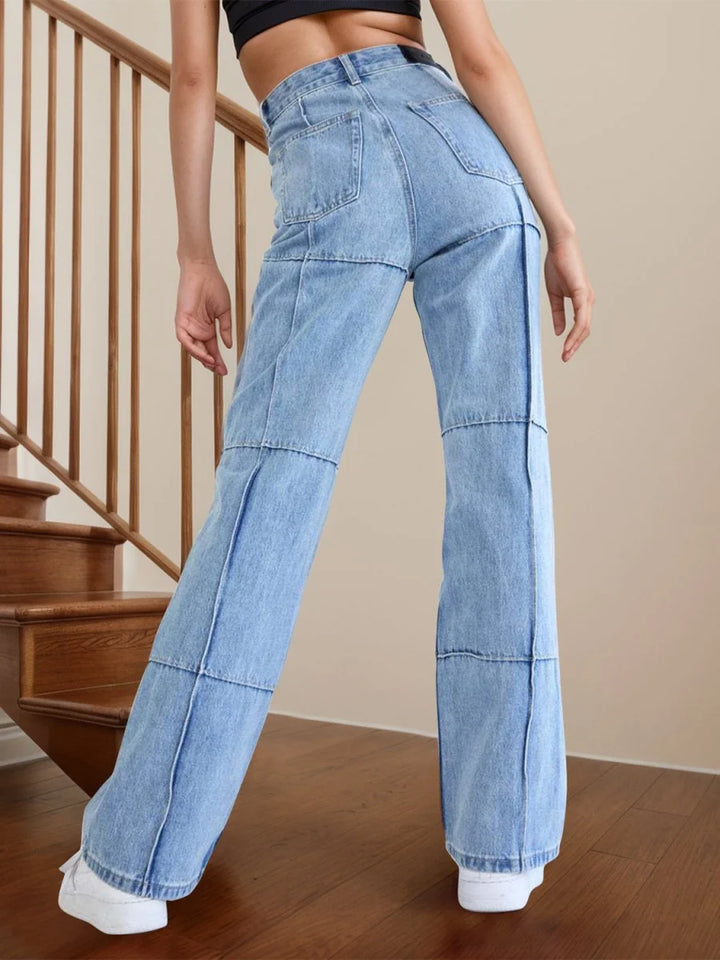 Light wash denim jeans with patchwork detail and wide leg, on model.