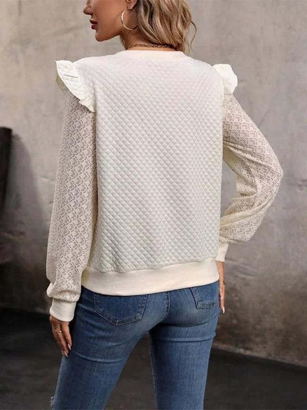 Cream quilted sweatshirt with sheer patterned sleeves and ruffled shoulders on model.