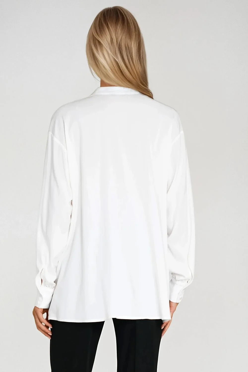 Back view of a white oversized viscose shirt with long sleeves on a model.