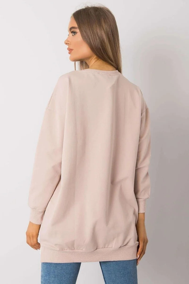 Loose-fitting light pink long-sleeve top with crew neck and ribbed cuffs and hem.