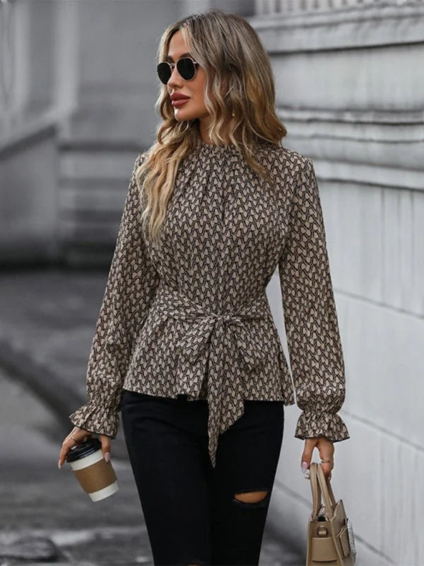 Brown and tan geometric print blouse with tie waist and ruffled cuffs on model.