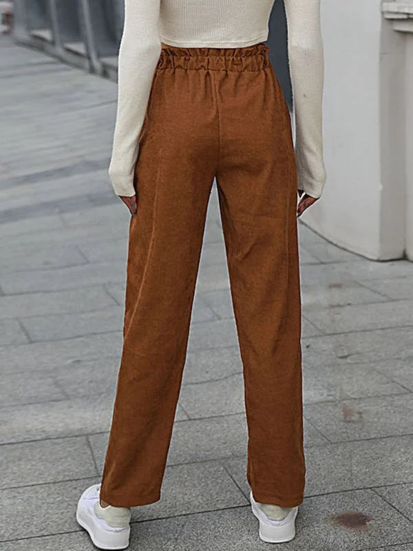 Brown corduroy pants with paperbag waist and wide legs, worn with white sneakers.