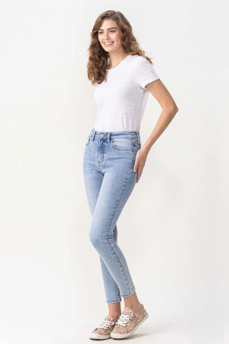 Light wash denim jeans with a high waist and a fitted silhouette, worn by a model.