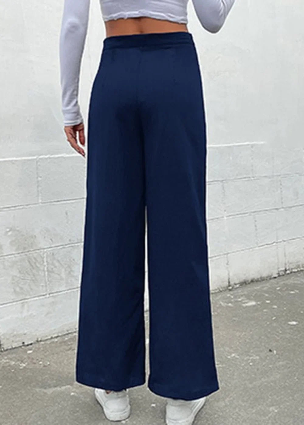 Navy blue wide-leg pants with a smooth texture, shown from the back on a model.