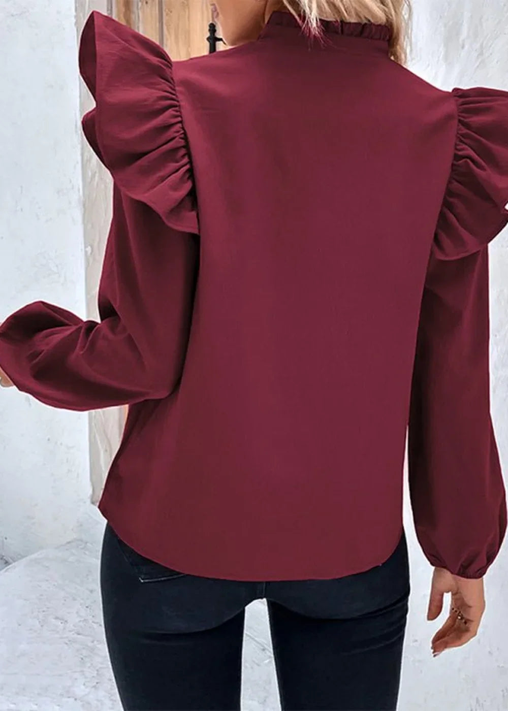 Burgundy long-sleeve top with ruffled shoulders and mock neck, shown from the back.