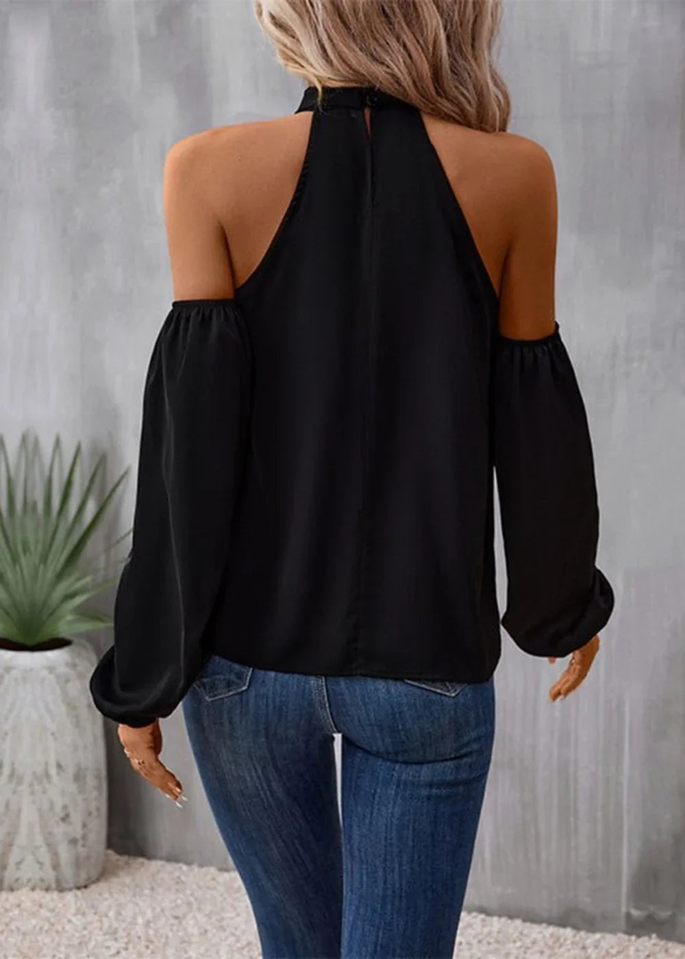 Black cold-shoulder halter top with long puffy sleeves.