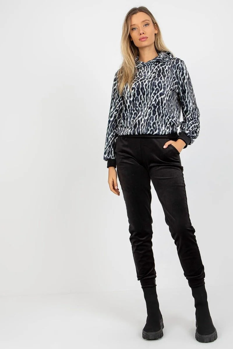 Black velvet joggers with a black and white leopard print hoodie on a model.