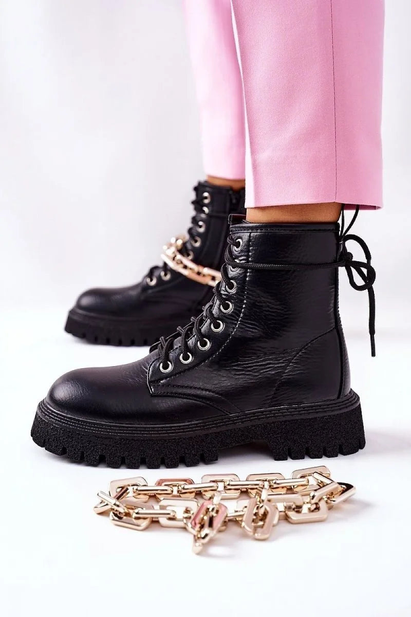 Black faux leather combat boots with chunky soles and gold chain detail.