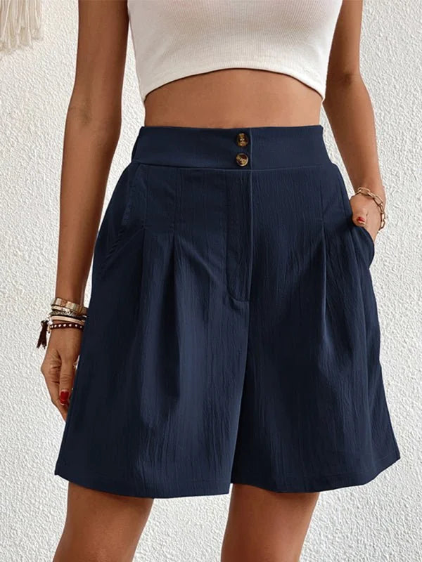 Navy blue textured shorts with a high waist and double button closure, on a model.