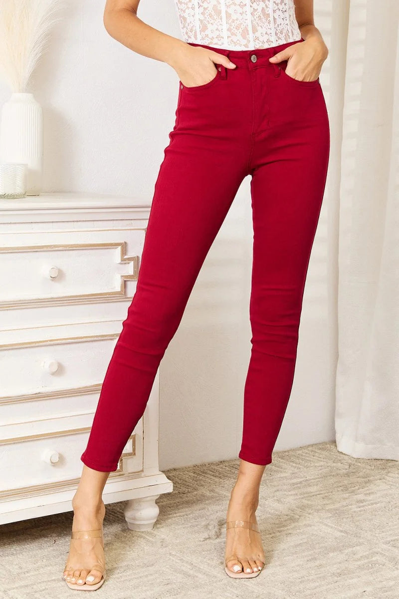 Red skinny jeans with a high waist, made of cotton blend, shown on model.