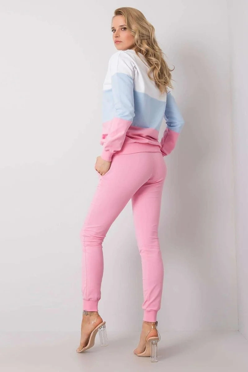 Woman wearing pink sweatpants and a color-blocked sweatshirt with white, light blue, and pink sections.