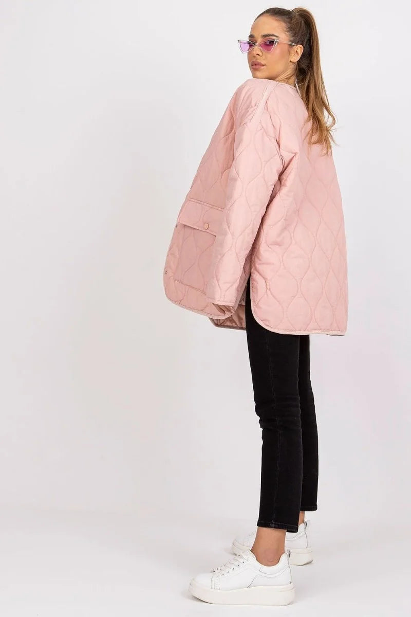 Light pink quilted jacket with a diamond pattern and two front pockets, worn by a model with black jeans and white sneakers.