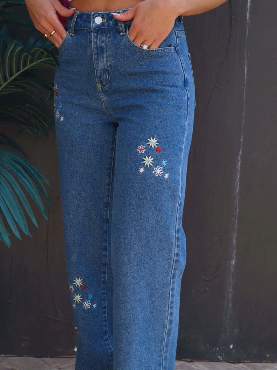 Blue denim jeans with embroidered floral accents and a regular fit.