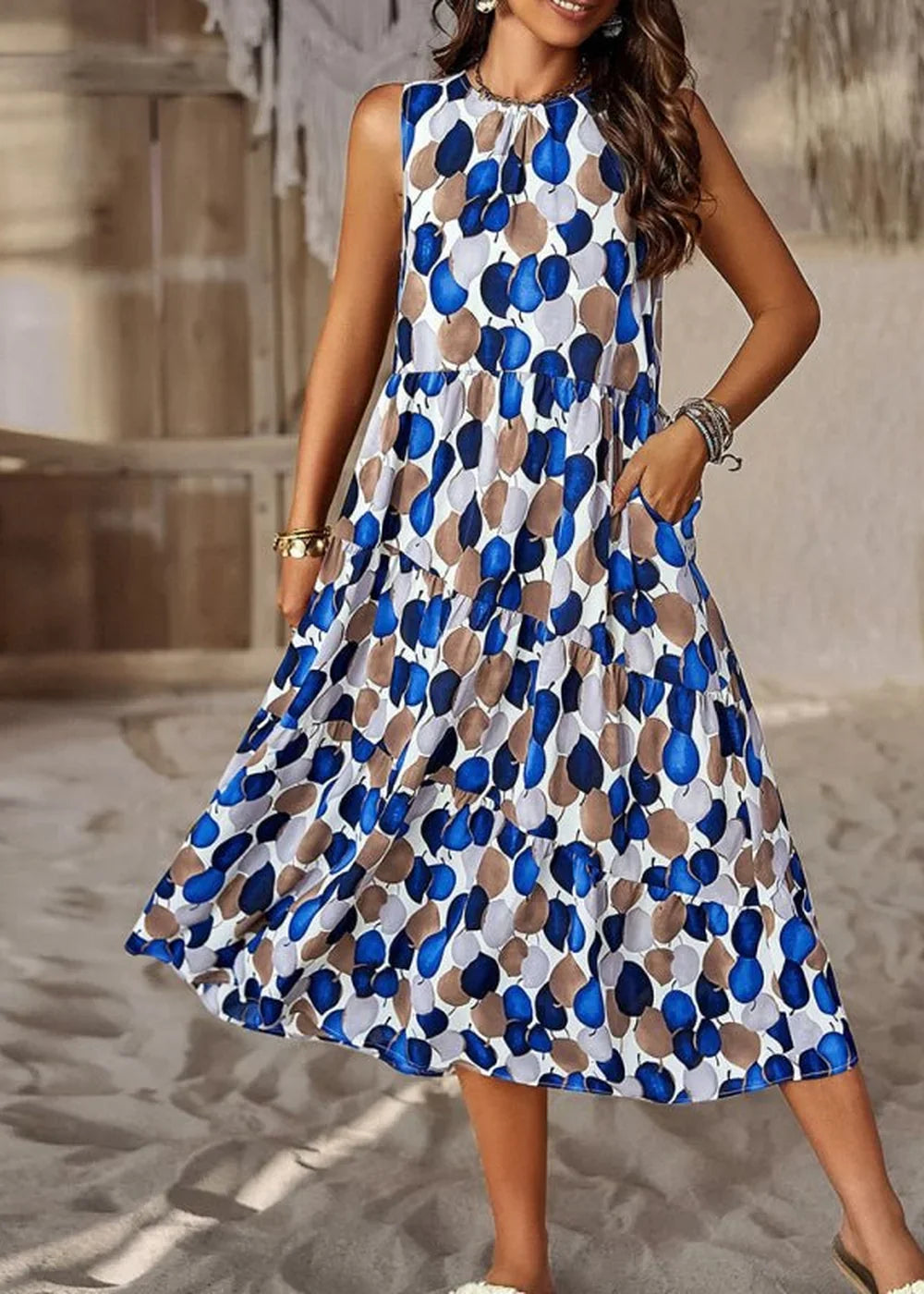 Blue, brown, and white abstract floral print tiered midi dress with pockets on model.