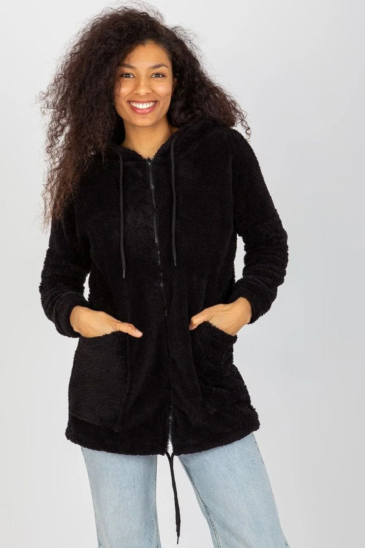 Black fluffy zip-up hoodie with pockets on a woman wearing light wash jeans.
