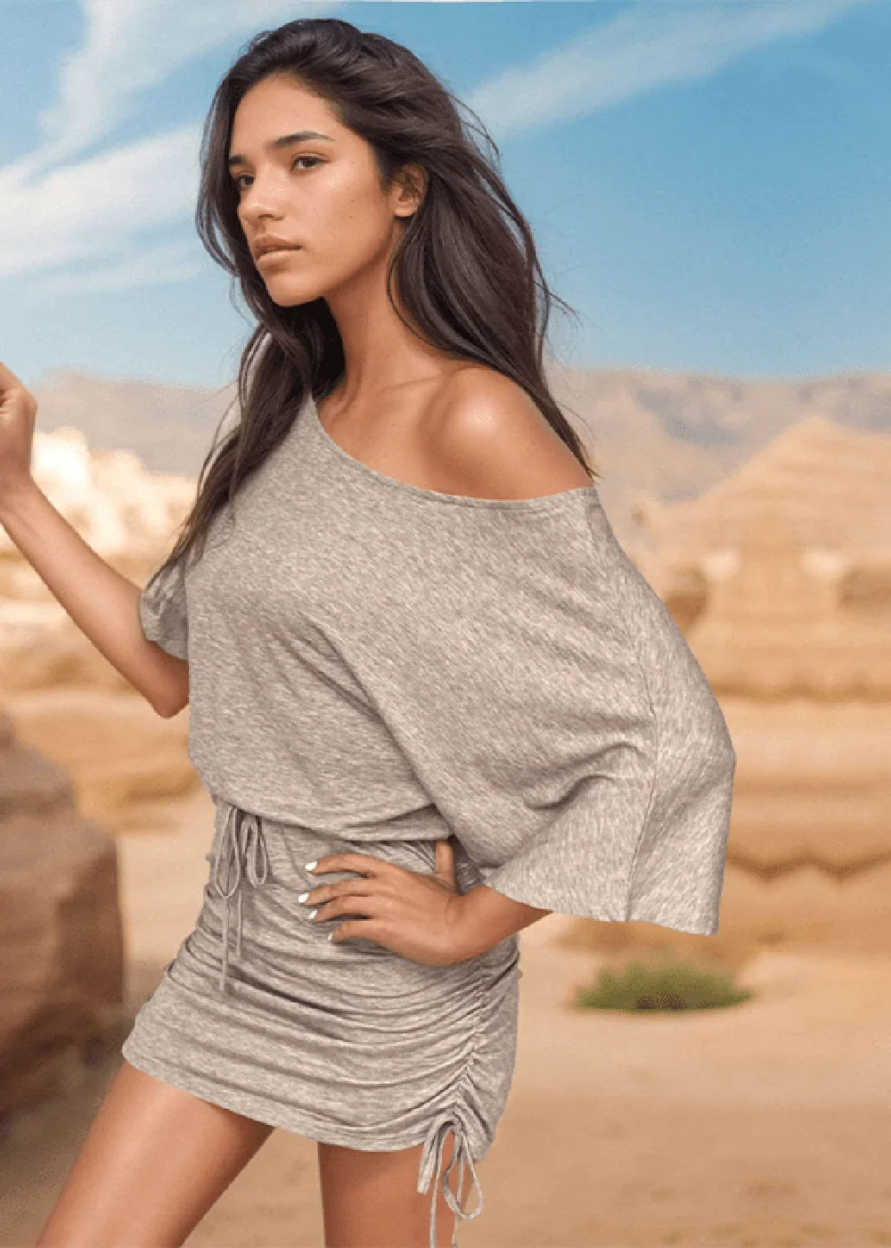 Model in a ruched grey off-the-shoulder mini dress with drawstring details.