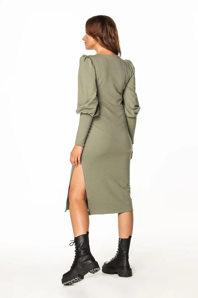 Olive green long-sleeve midi dress with thigh-high slit and puffed sleeves, worn with black combat boots.