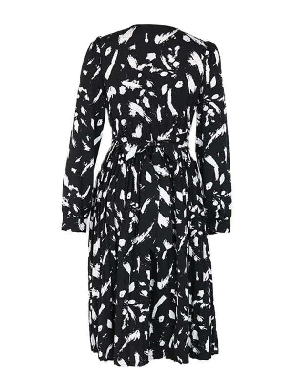 Black and white abstract print midi dress with long sleeves and a tie waist.