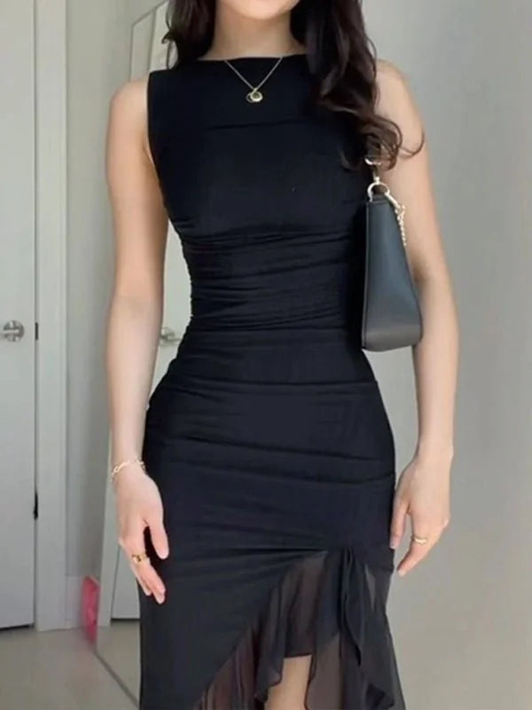 Black ruched midi dress with sheer ruffled hem, worn by a model with a gold necklace and black purse.