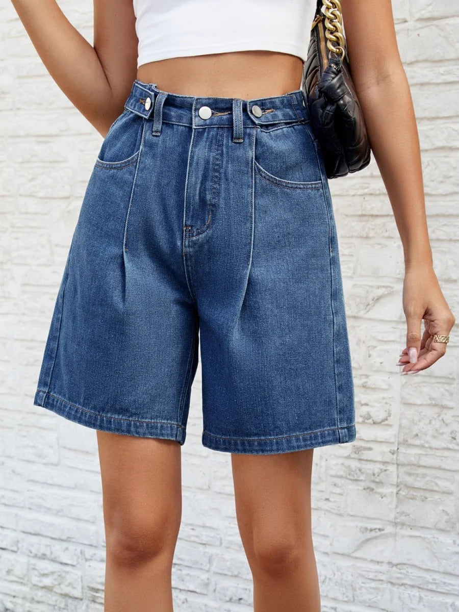 Medium wash denim shorts with pleated front and relaxed fit.
