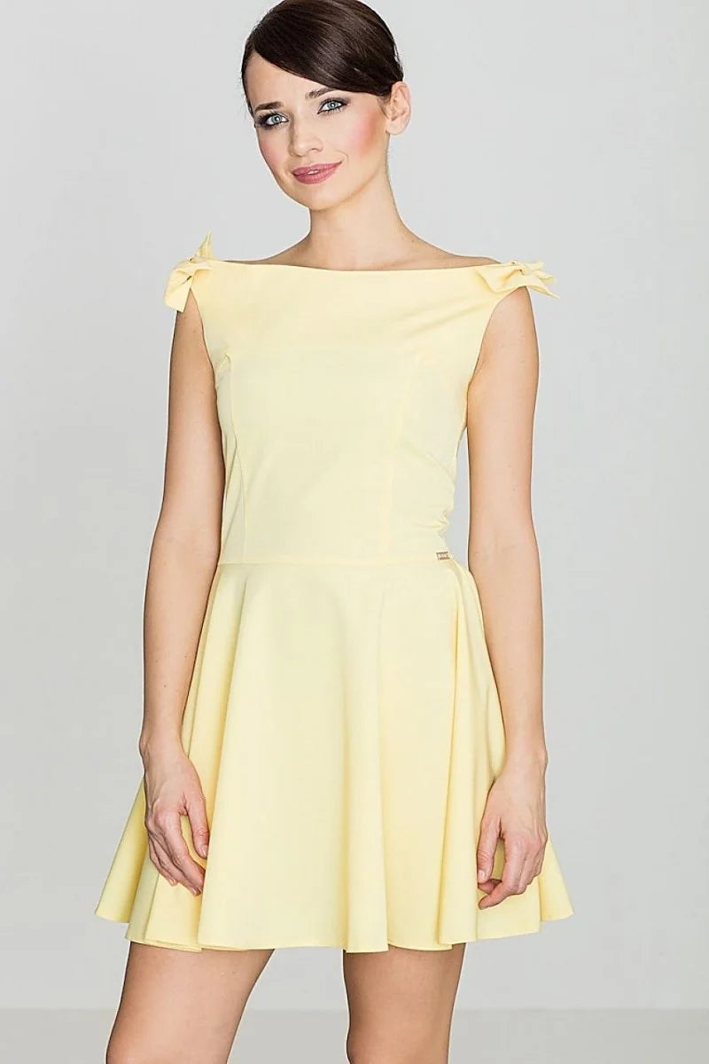 Pale yellow cocktail dress with off-the-shoulder neckline and bow details on shoulders.