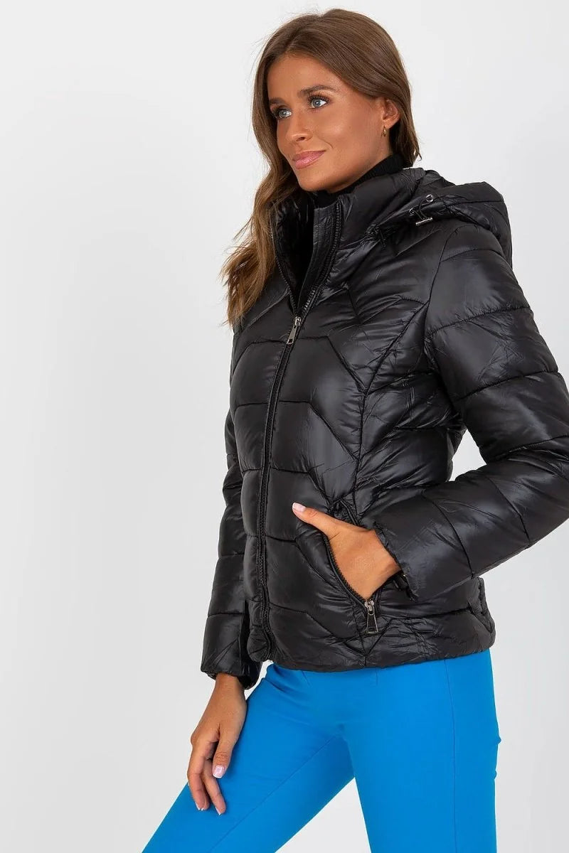 Black puffer jacket with a quilted pattern and a zippered front, worn by a model.