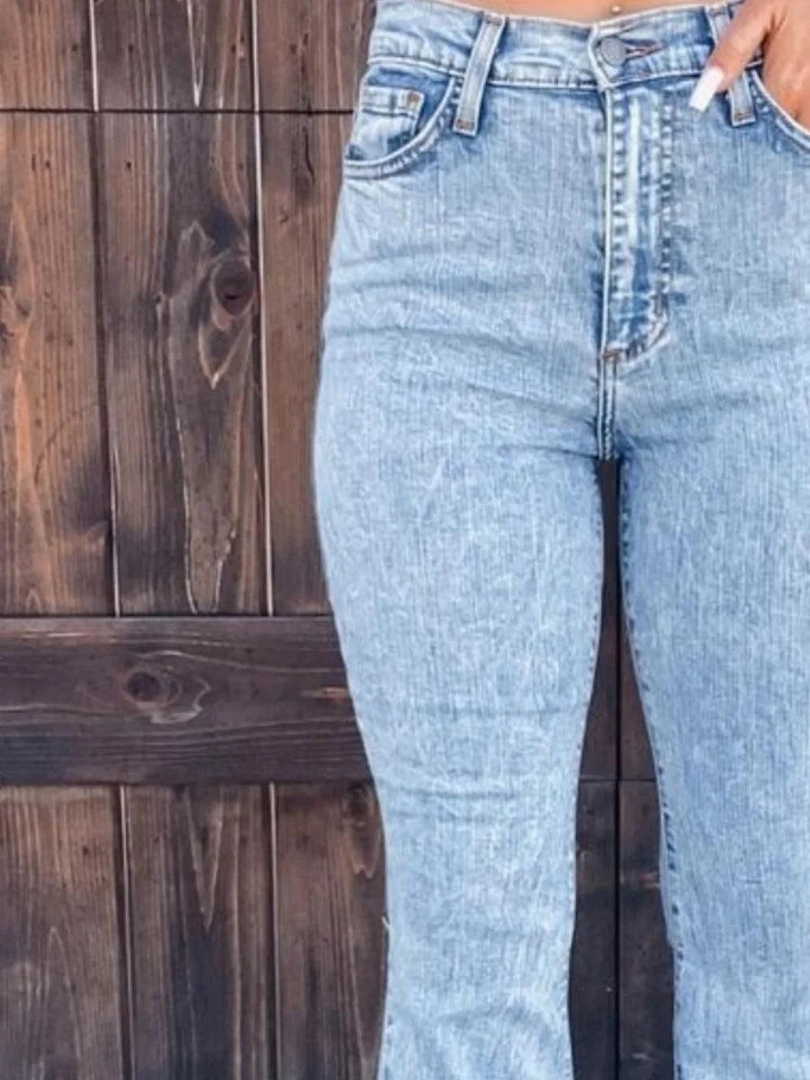 Model wearing light blue raw hem bootcut jeans.