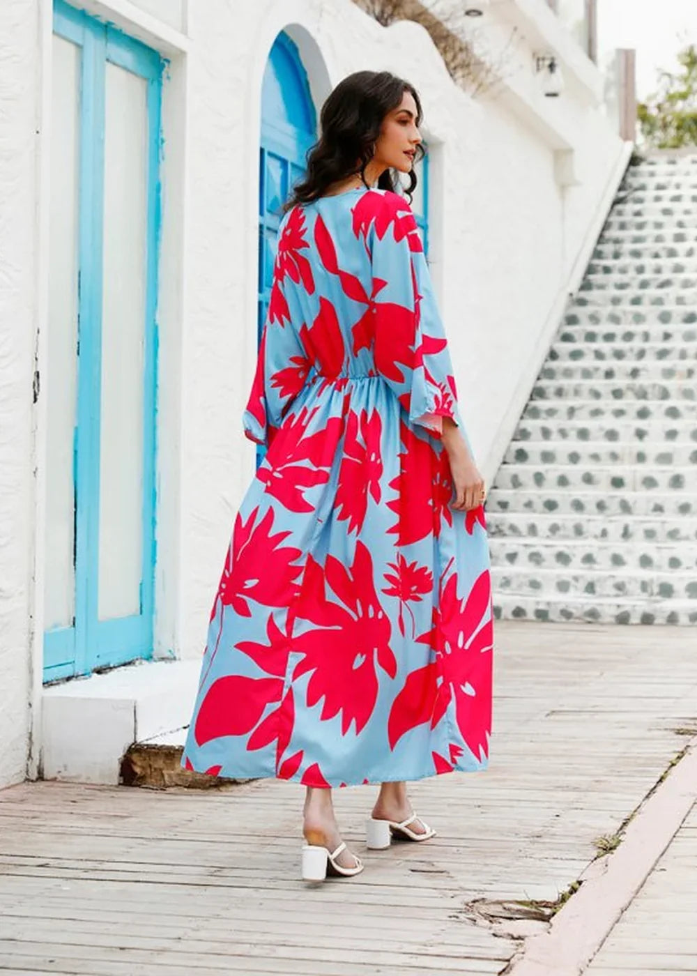 Light blue maxi dress with a vibrant red floral print, featuring wide sleeves and a cinched waist.
