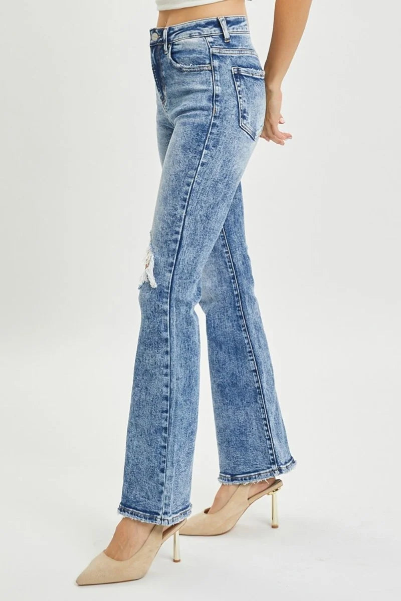 Model wearing high rise distressed flare jeans