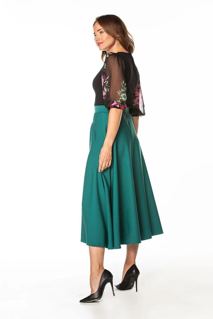 Teal A-line skirt with a smooth texture, worn with black heels.