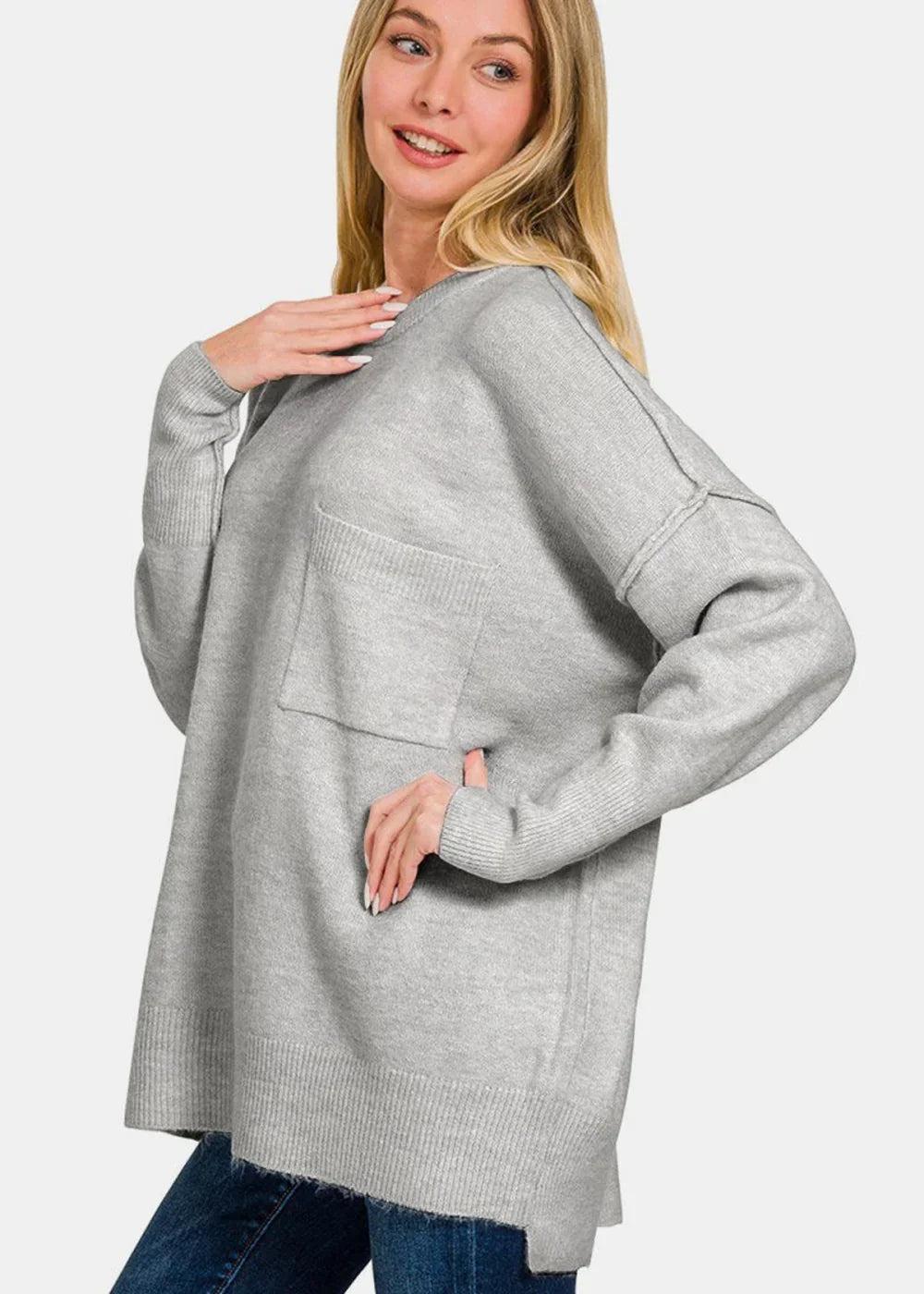 Light gray knit sweater with a chest pocket and ribbed trim on a model.