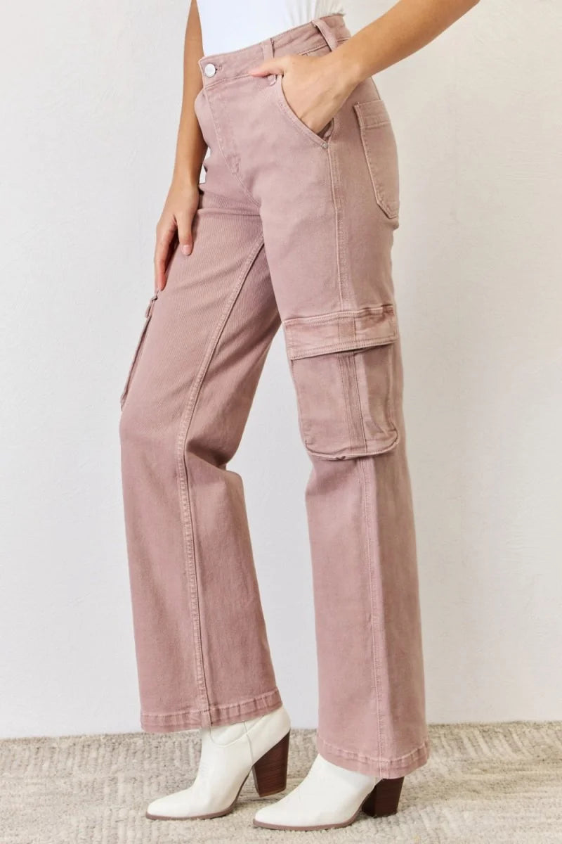High-rise dusty rose cargo pants with a wide leg and white boots.
