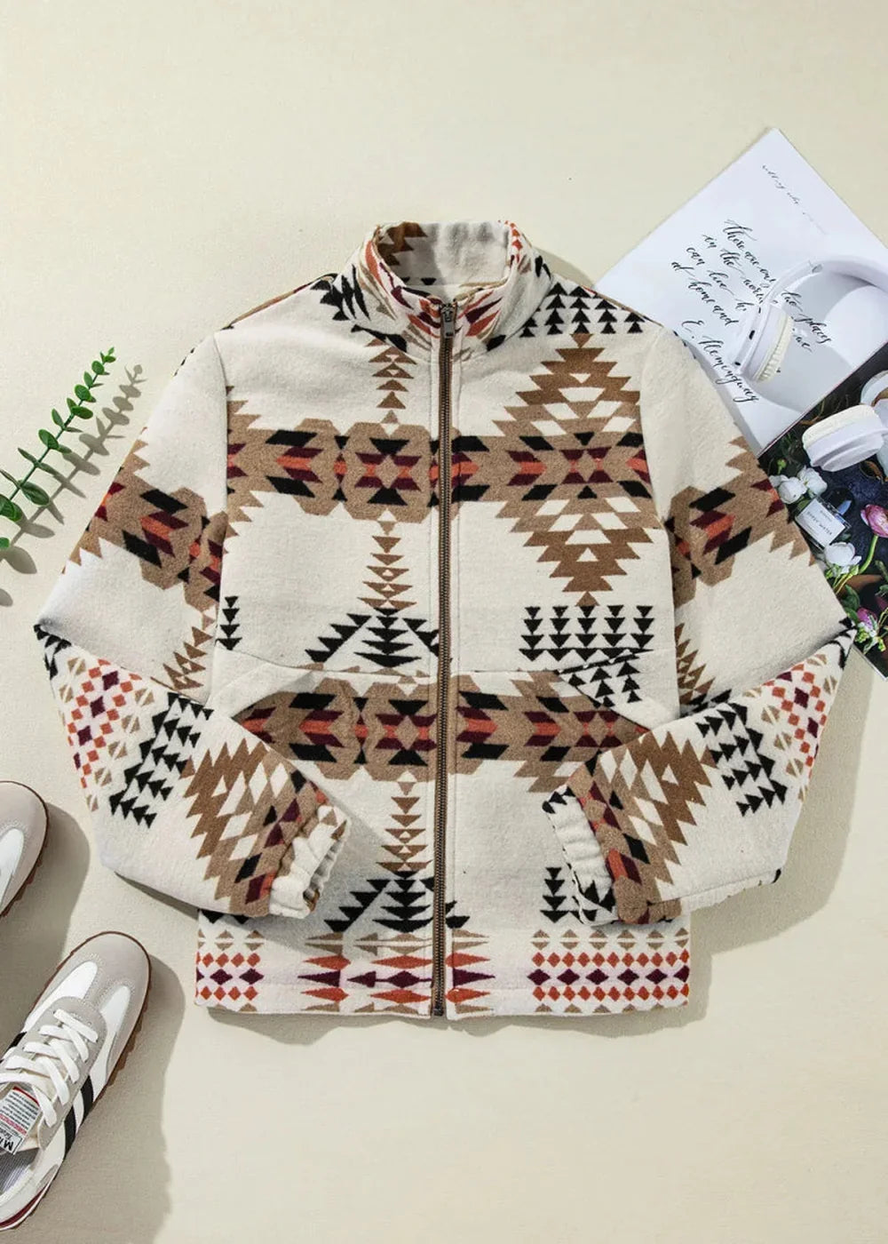 Cream jacket with geometric Navajo-inspired print in brown, black, and rust, full zip, and mock neck.