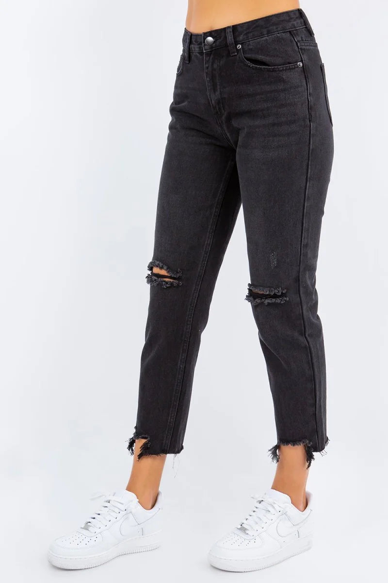 Distressed black high-waisted denim jeans with frayed hem and raw edges.