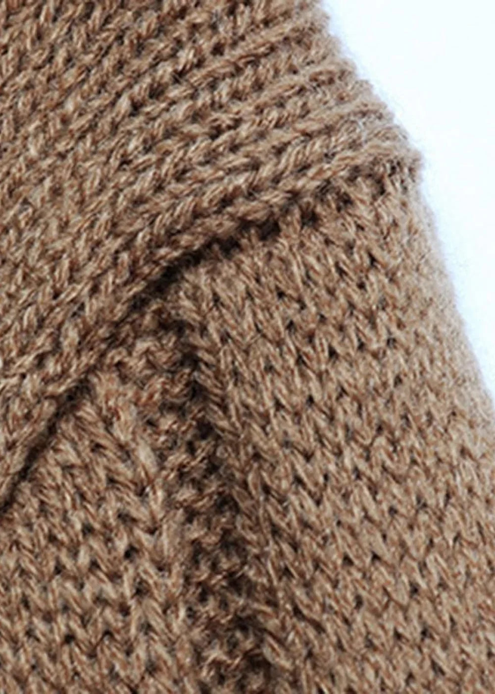 Close-up of a brown, textured knit sweater fabric with visible stitching detail.