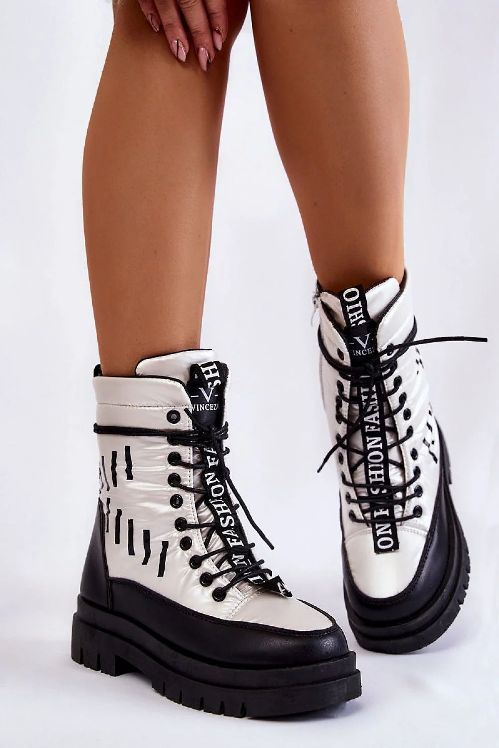 White and black lace-up combat boots with "Fashion" text detail on a platform sole.