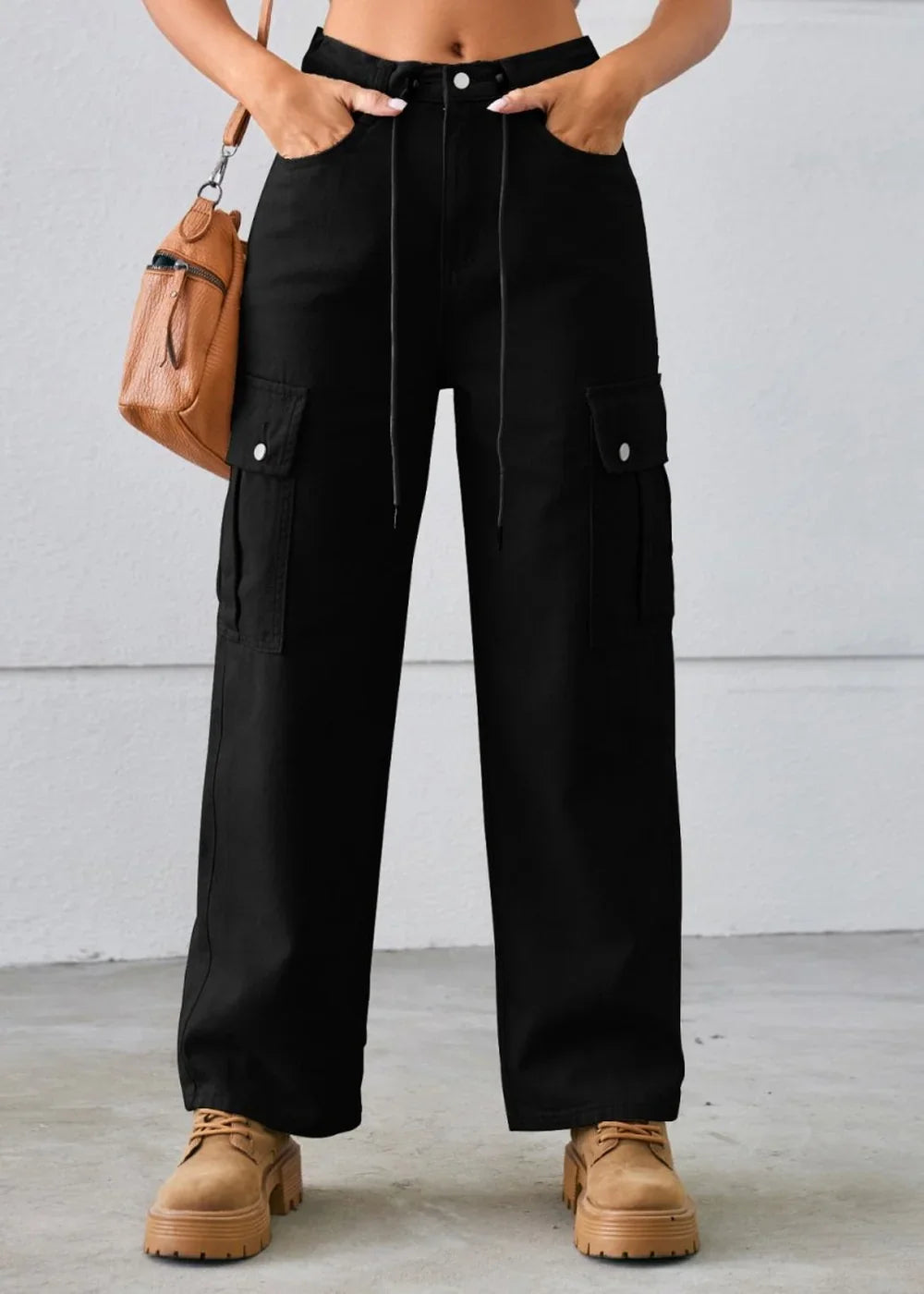 Model wearing black cargo jeans with a casual top