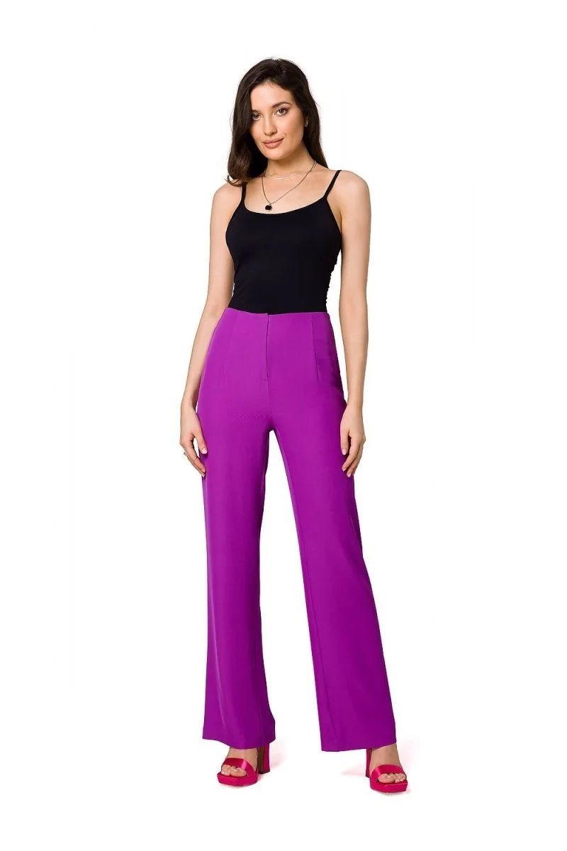 Full-length shot of a woman wearing vibrant purple wide-leg pants with a black tank top.