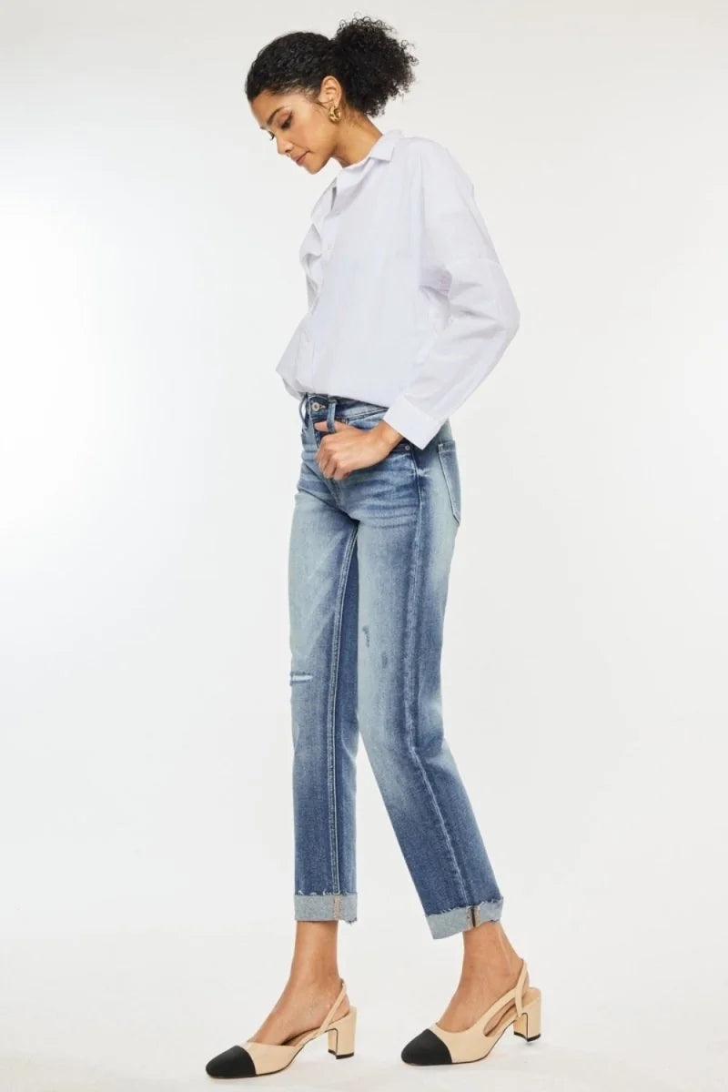 Model in light wash distressed denim jeans with cuffed hems and a white button-down shirt.