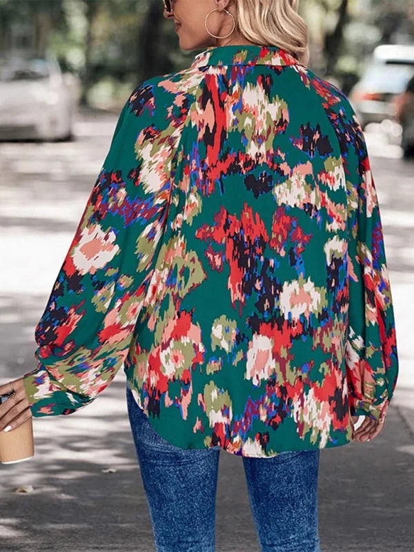 Green long-sleeve top with a vibrant abstract print in red, pink, and blue, worn by a model.