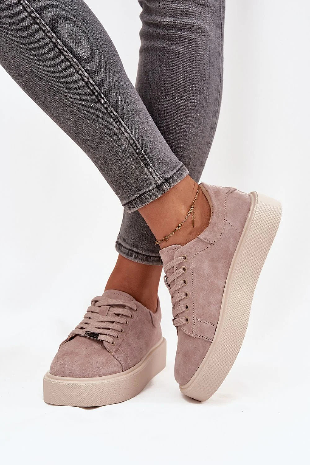 Light pink suede platform sneakers with laces and a gold anklet on a model.