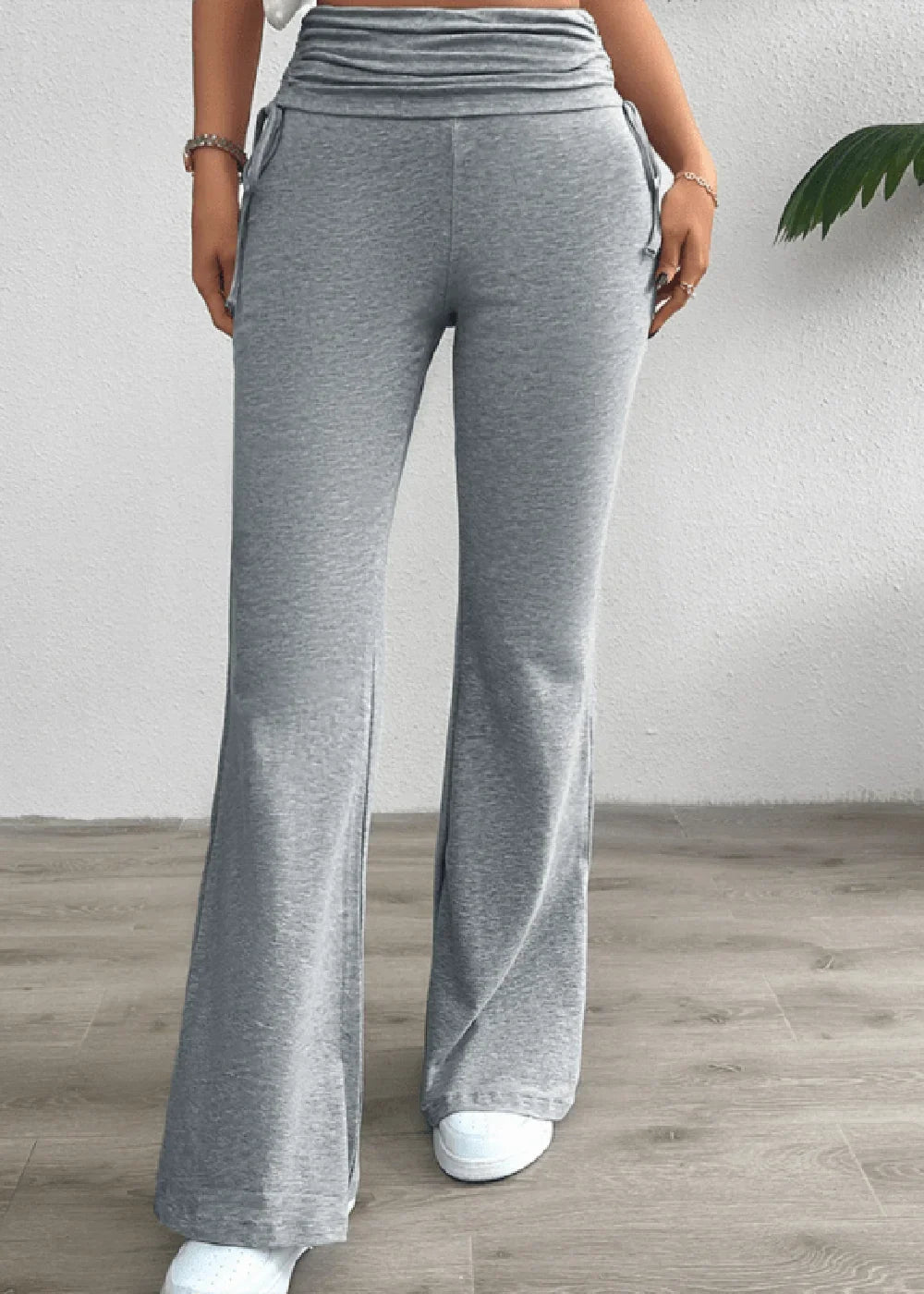 Grey flared sweatpants with ruched waistband and drawstring detail, full length on model.