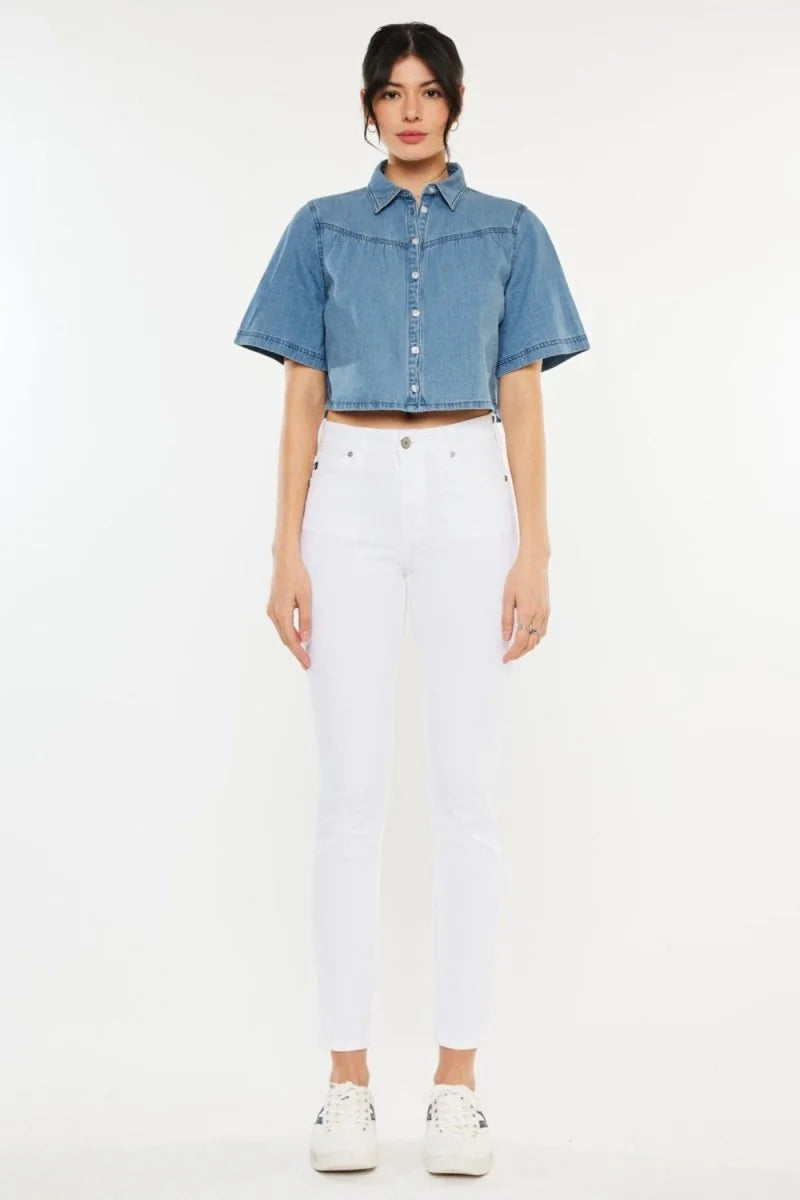 Model in white jeans and a blue denim cropped shirt with a pointed collar and short sleeves.